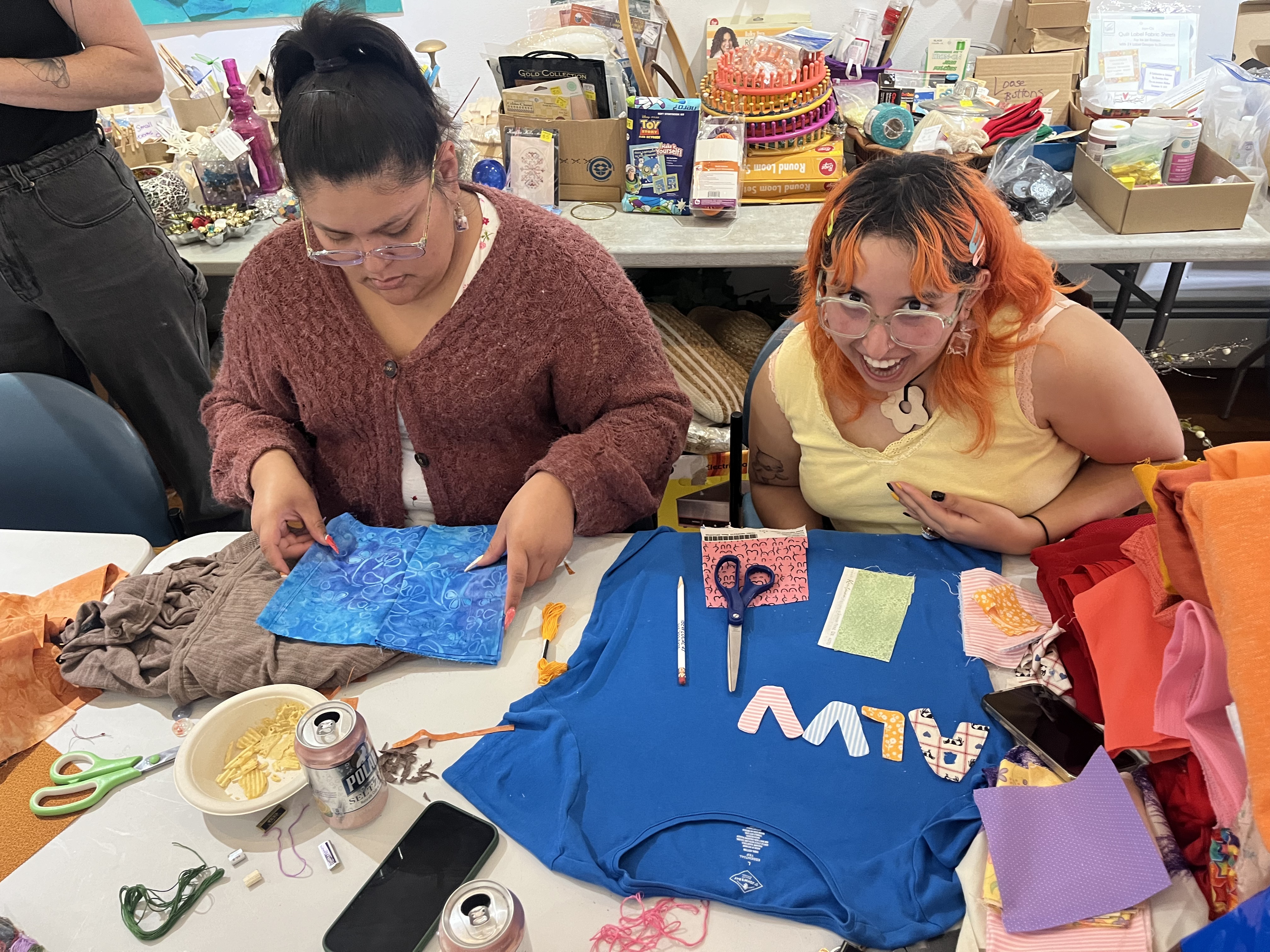 Two women at a mending workshop