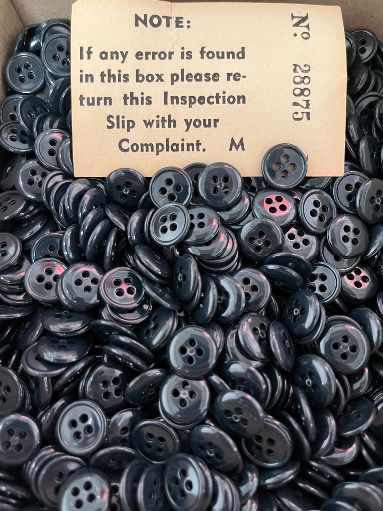 box of black buttons with vintage Inspection slip