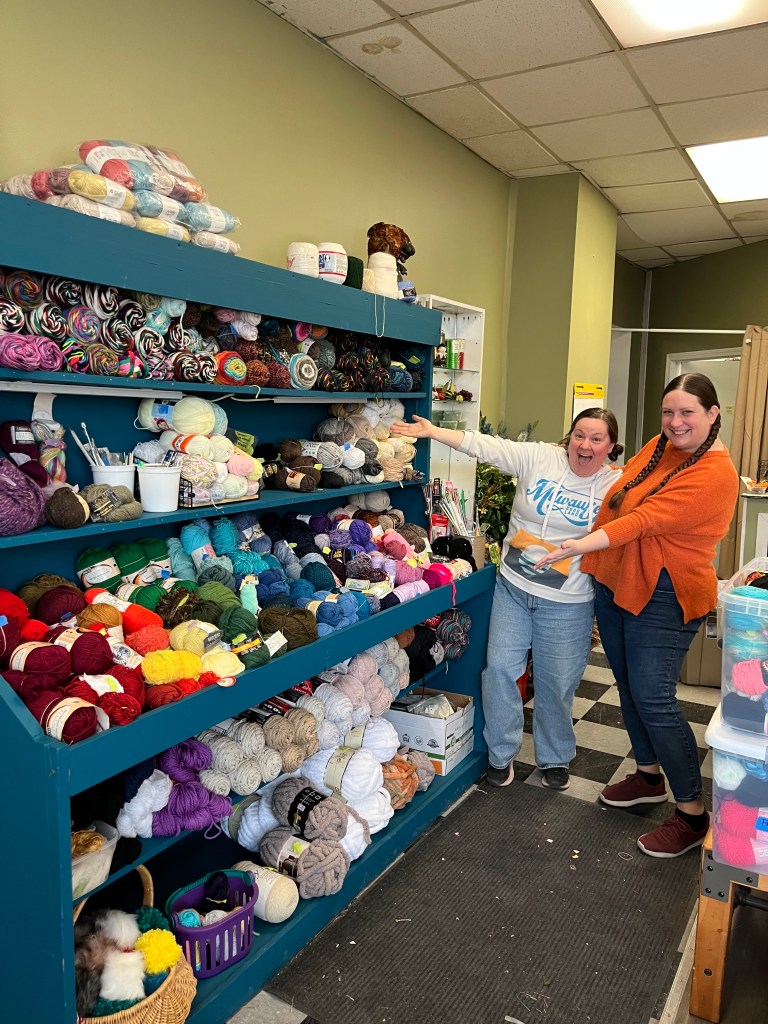 Volunteers posing with yarn display