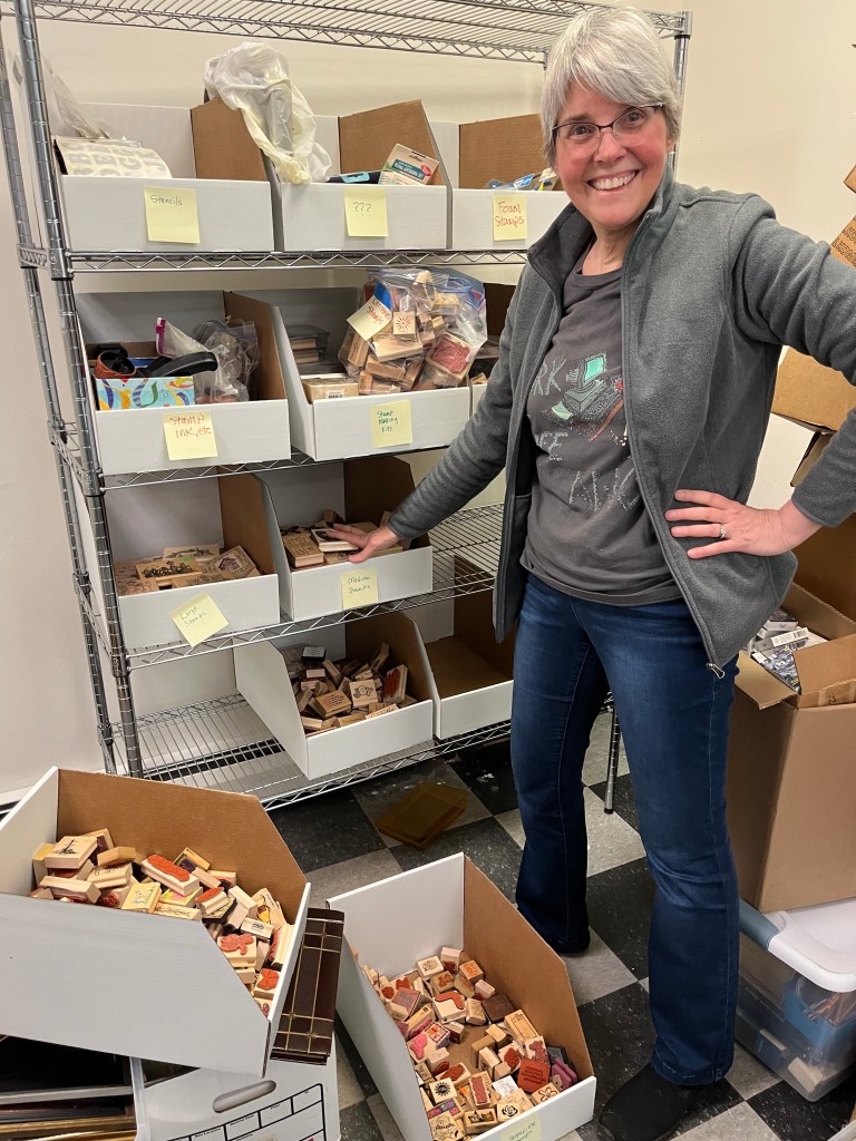 Volunteer posing with rubber stamp display